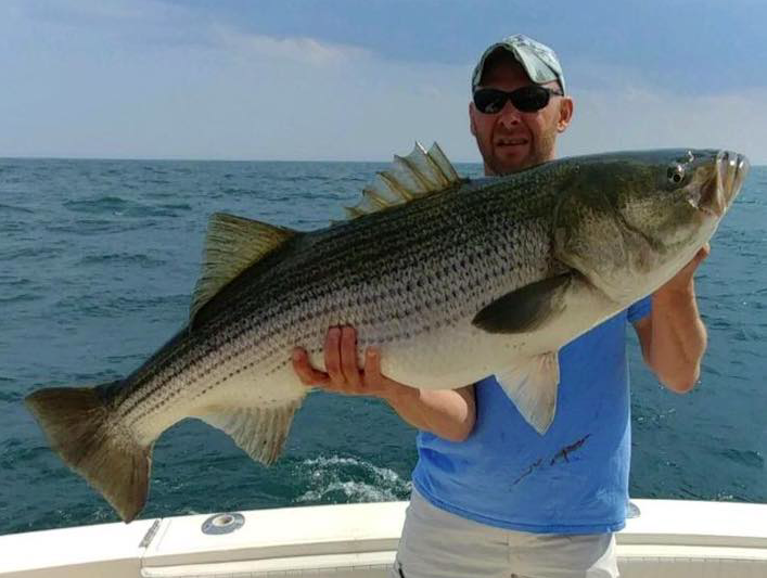 A customer at The Dock Outfitters with a 53-pound striped bass he caught. (Photo: Dock Outfitters)