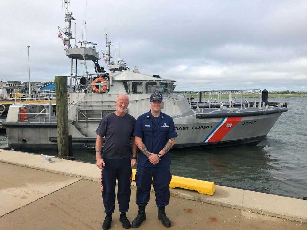 Petty Officer 2nd Class Eric Thornton, a Surfman at Coast Guard Station Barnegat Light, poses for a photo with Duncan Hutchison, Monday, June 4, 2018. A 47-foot Motor Lifeboat (MLB) crew from Station Barnegat Light launched to respond and rescued Duncan after he became beset by weather about 20 miles east of Barnegat Light, New Jersey. (U.S. Coast Guard courtesy photo)