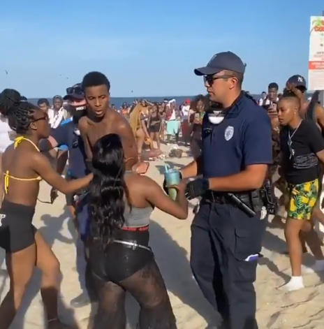 Police lead a partygoer off the beach in Point Pleasant Beach, June 9, 2020. (Screenshot: iam_champagne26/ Instagram)