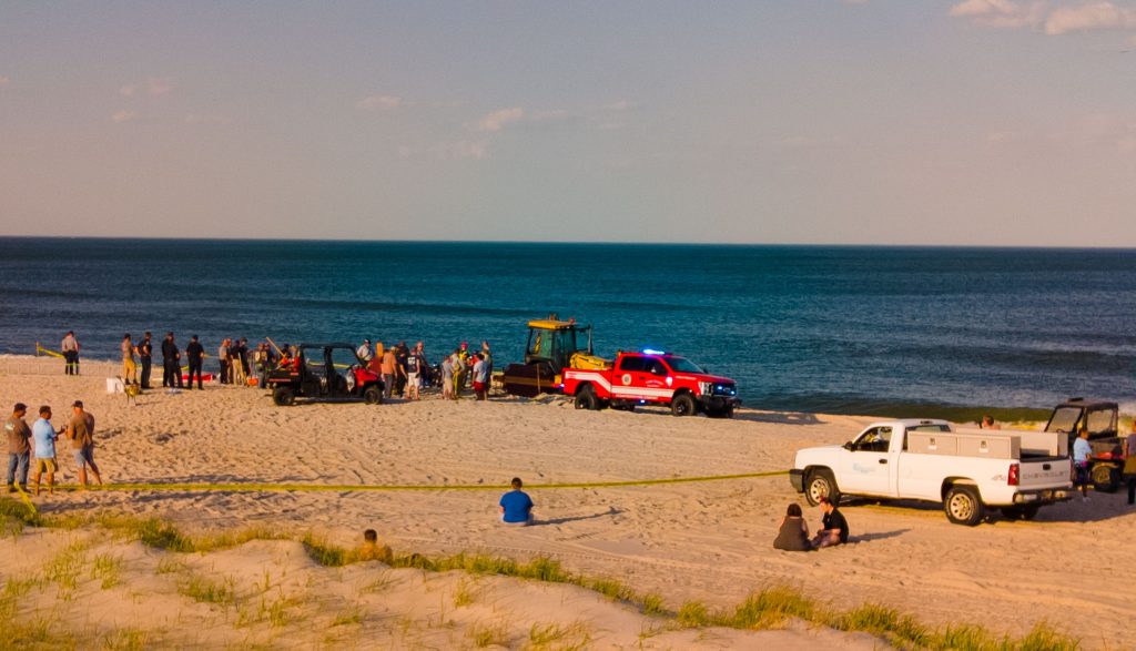 Rescue workers searching for a teen missing after a hole in the beach sand collapse, May 17, 2022. (Photo: Daniel Nee)
