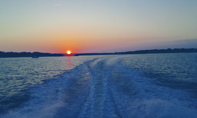 A hot summer sun sets behind a boat wake, July 2022. (Photo: Daniel Nee)