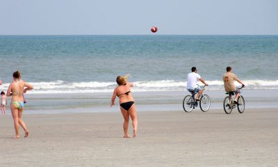 Beachgoers play football near the water. (Credit: Jon Dawson/ Creative Commons/ Flickr)